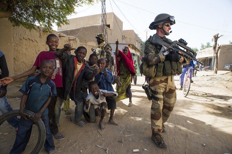 Soldier with children in village