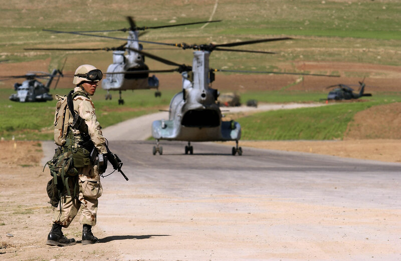 Soldier with helicopter in background