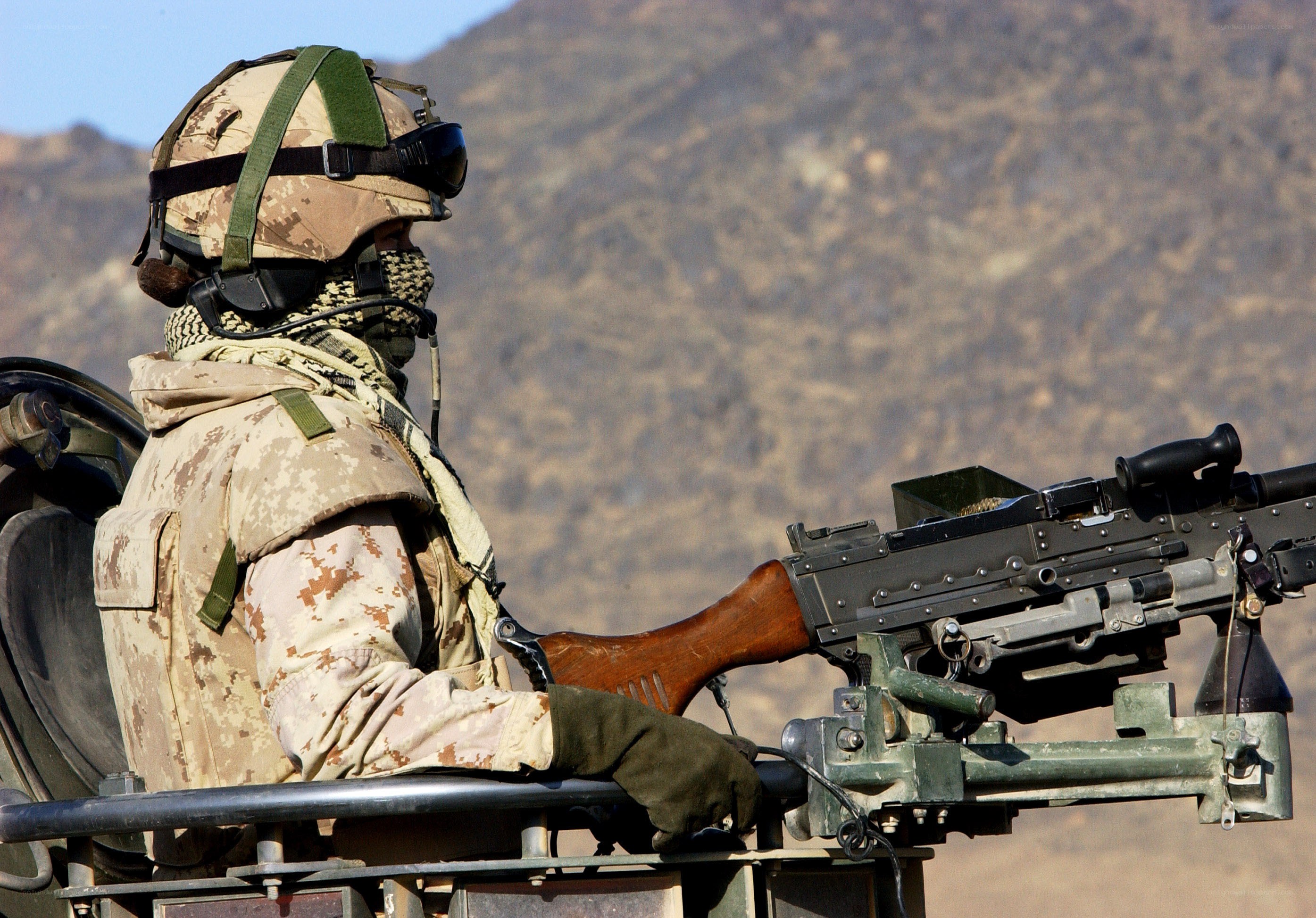 Soldier with machine gun in desert