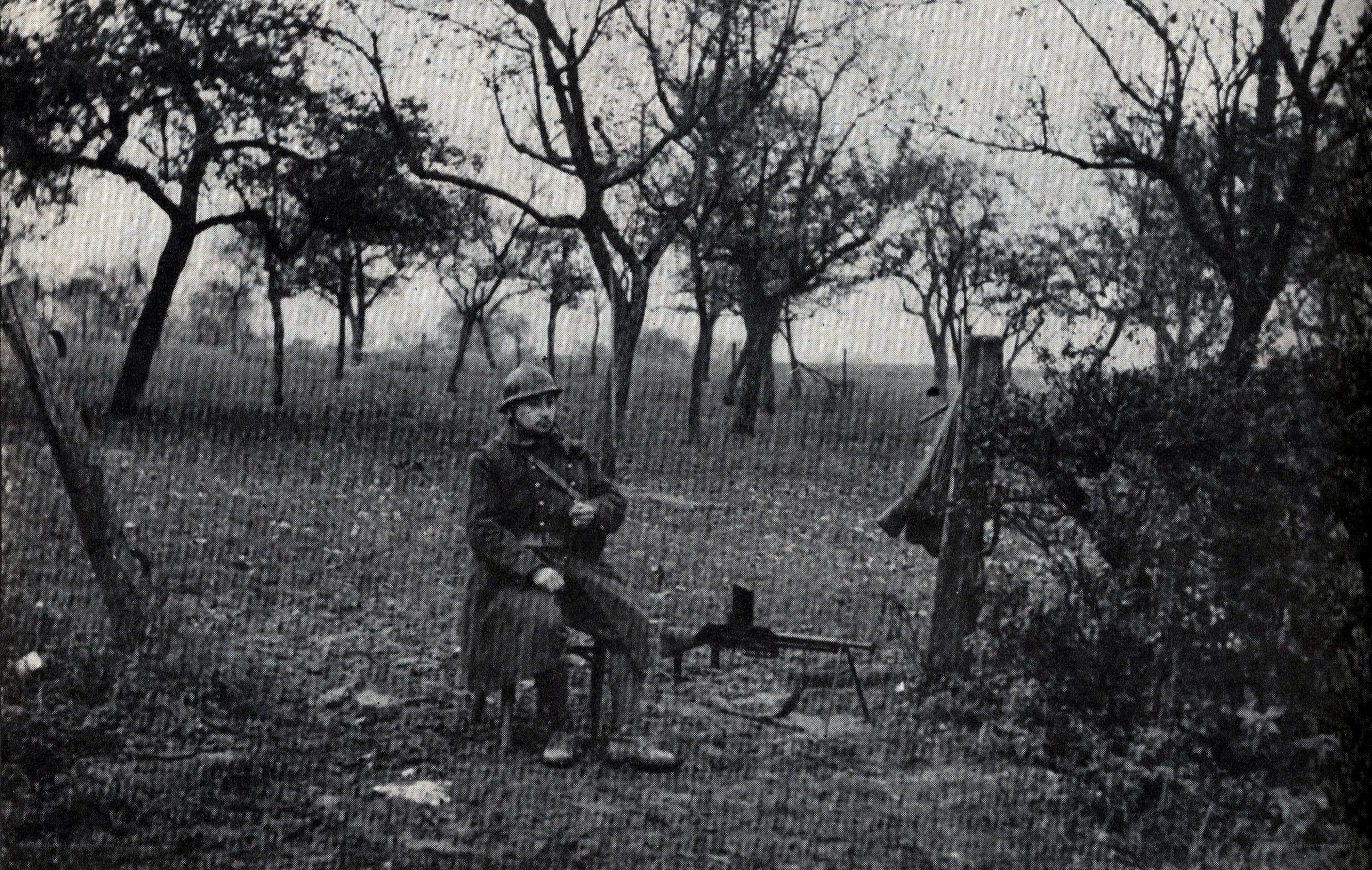 Soldier with machine gun in orchard