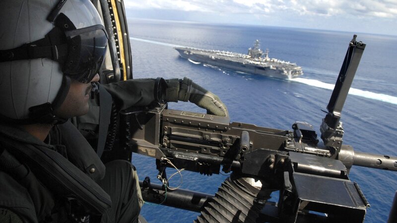 Soldier with machine gun on helicopter
