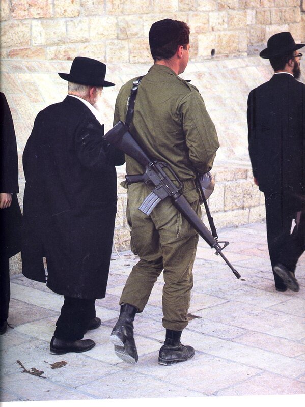 Soldier with rifle among religious men