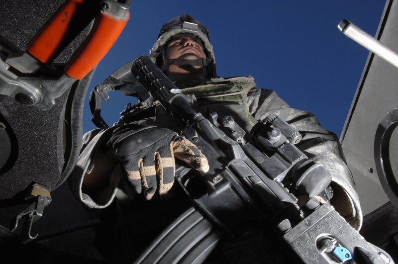 Soldier with rifle in vehicle