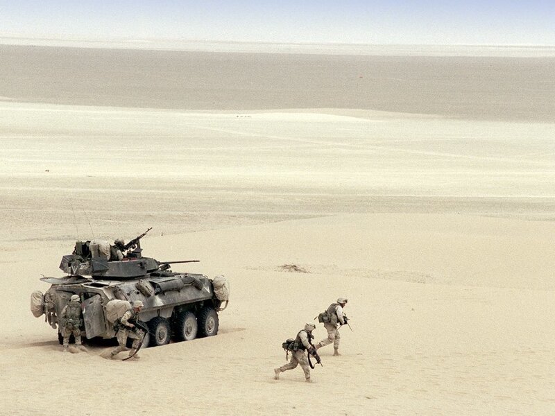 Soldiers and armored vehicle in desert