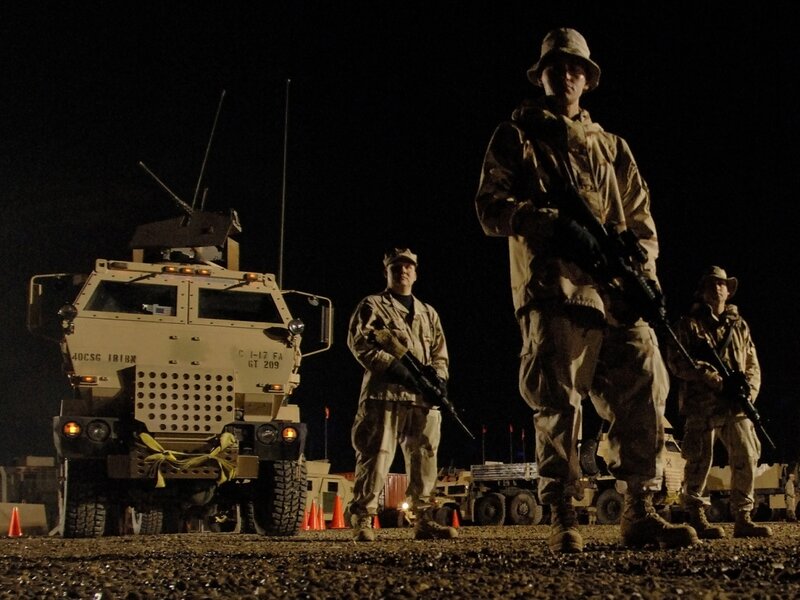 Soldiers at night with armored vehicle