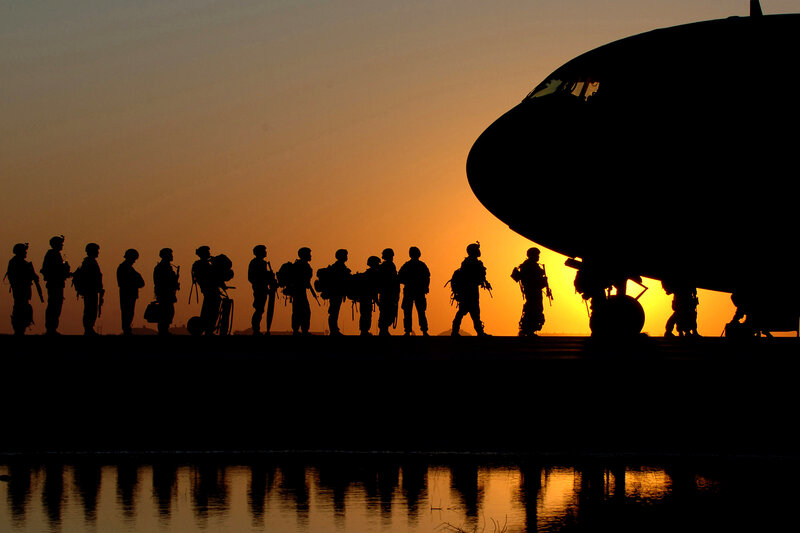 Soldiers boarding aircraft at sunset