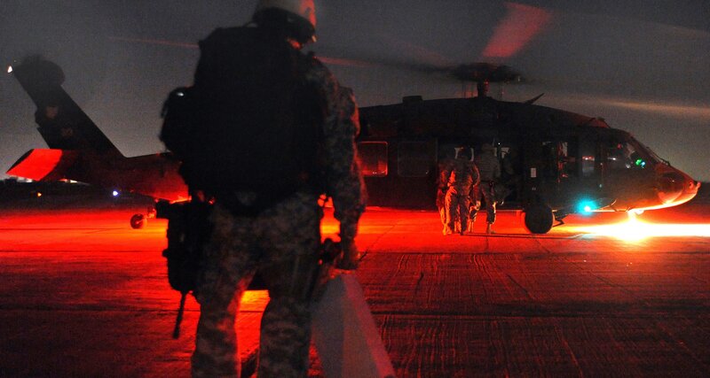Soldiers boarding helicopter at night