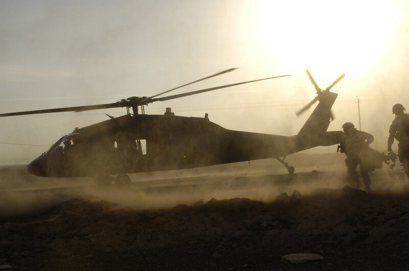 Soldiers boarding helicopter at sunset