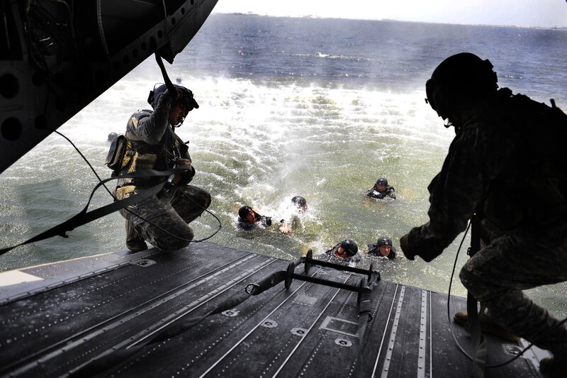 Soldiers boarding helicopter from water