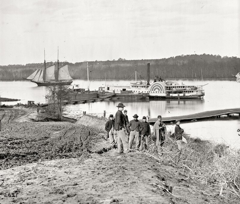 Soldiers by river with steamboat