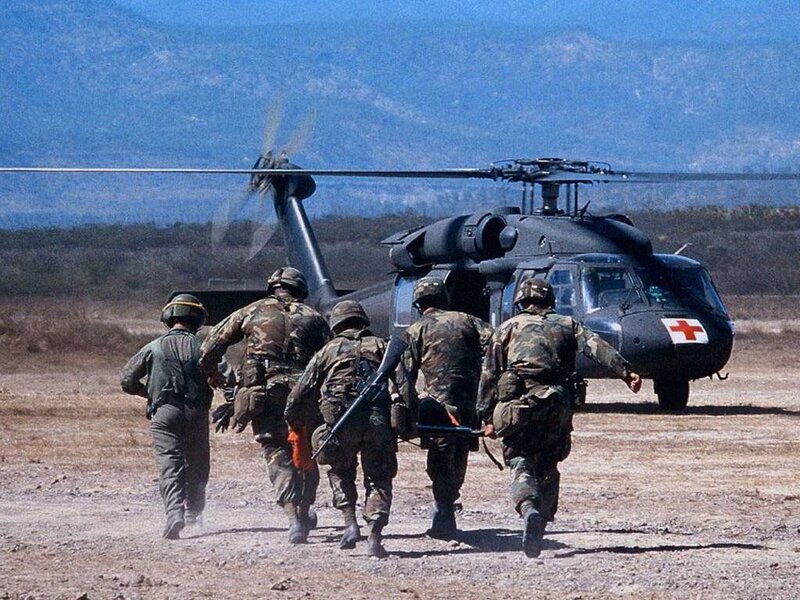 Soldiers carrying stretcher to helicopter