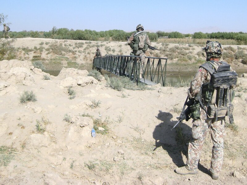 Soldiers crossing a river bridge