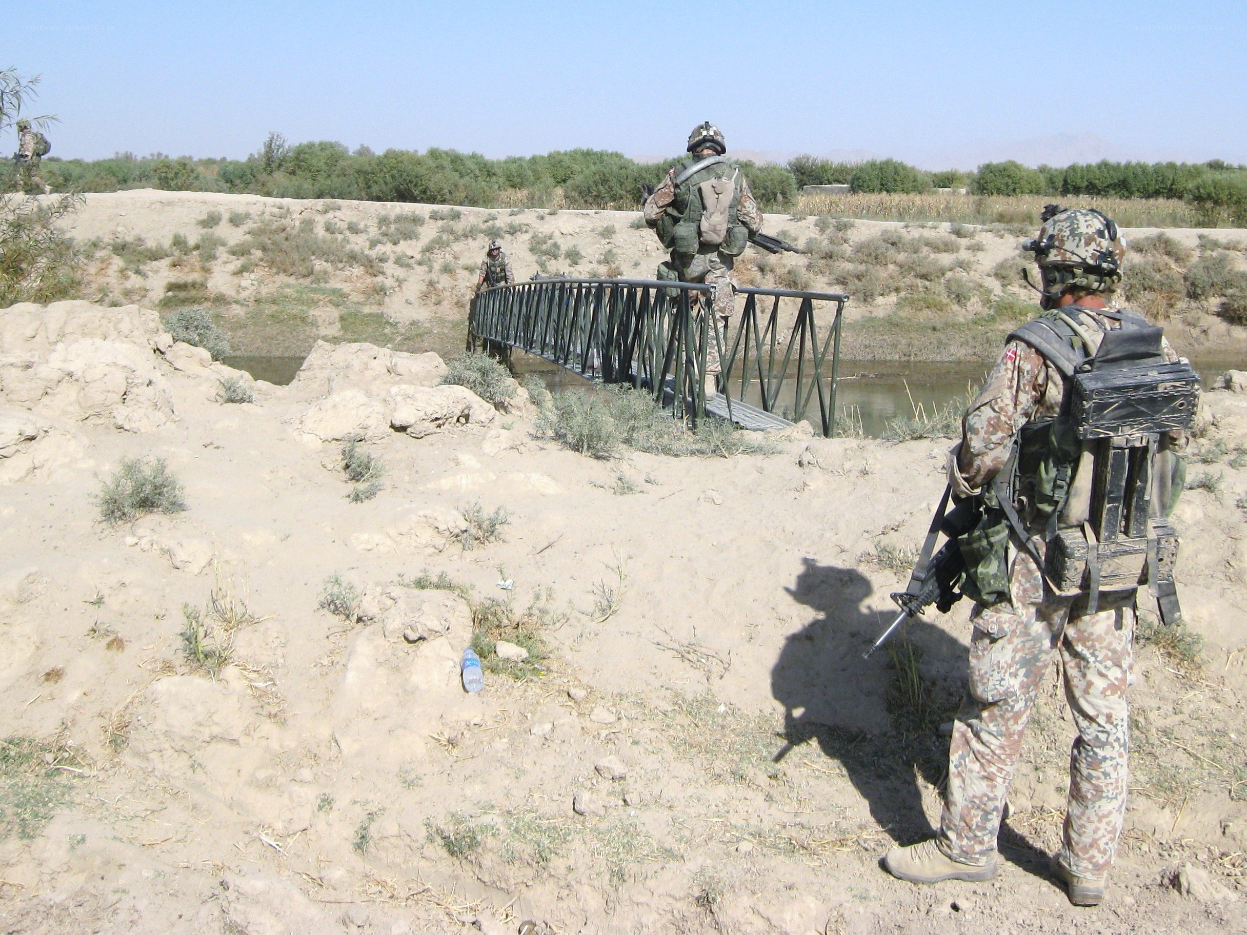 Soldiers crossing a river bridge