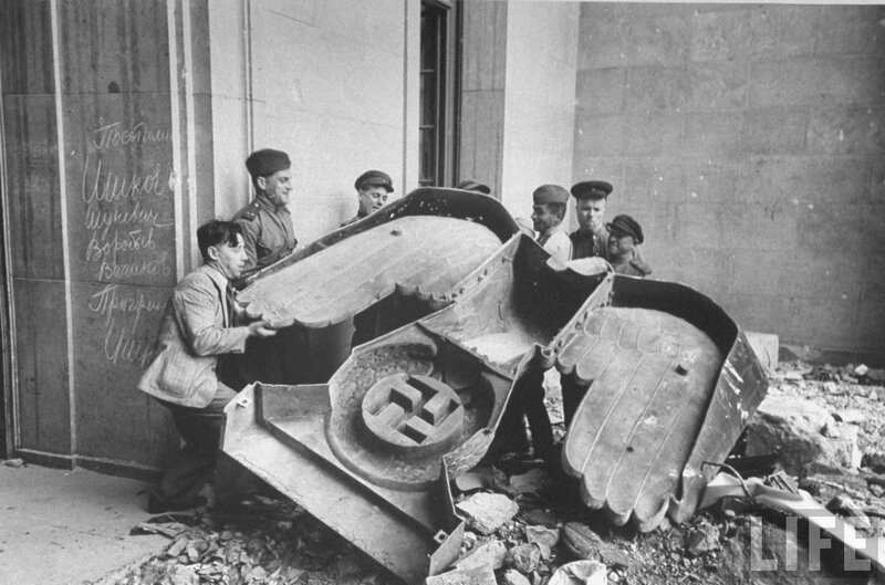 Soldiers dismantle Nazi emblem