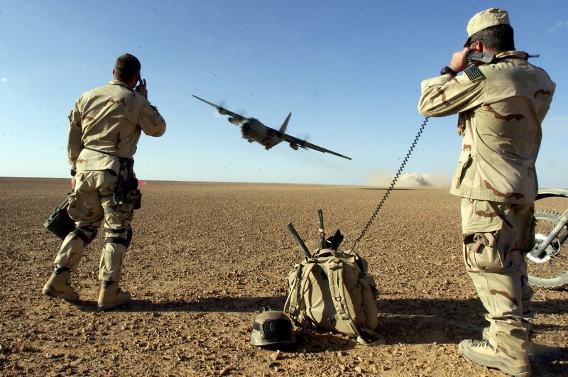 Soldiers guiding aircraft in desert