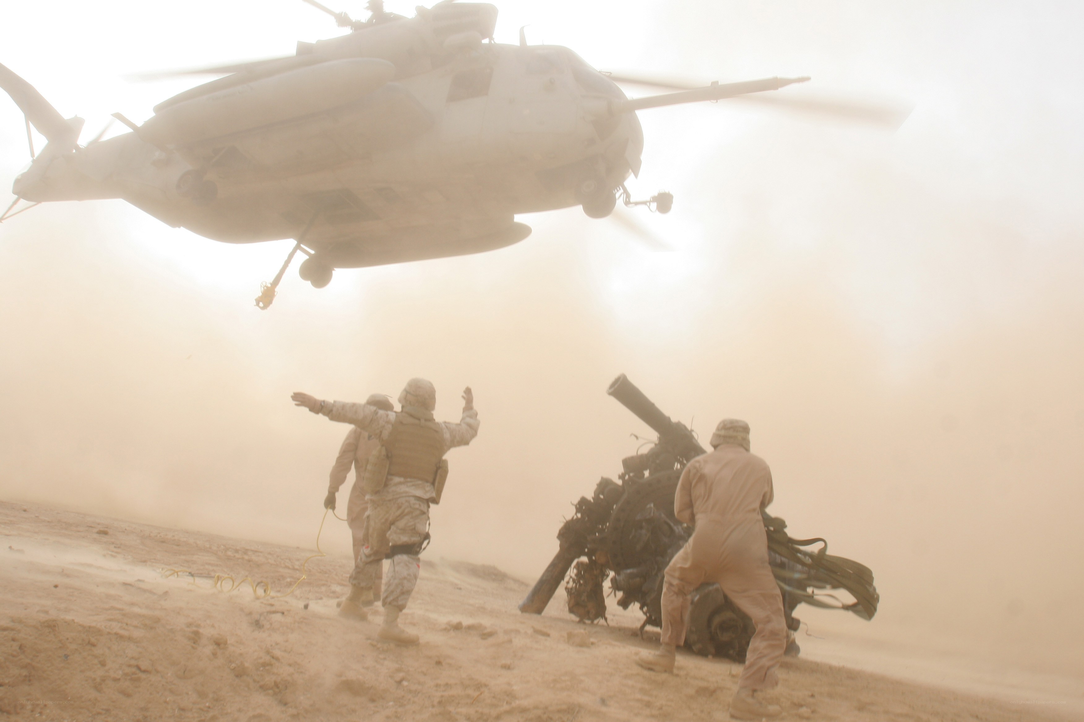 Soldiers guiding helicopter in desert