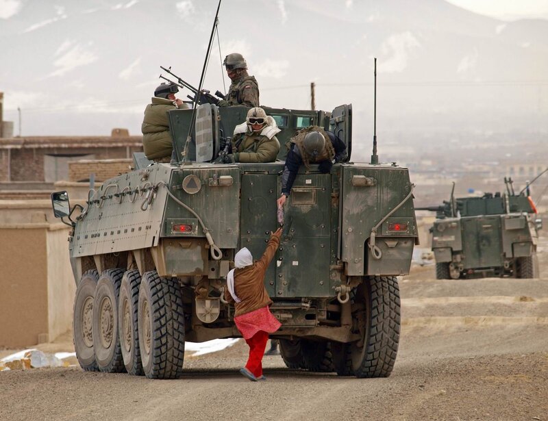 Soldiers in armored vehicle with child