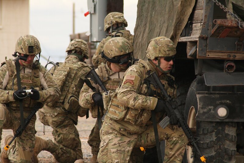 Soldiers in combat gear near vehicle