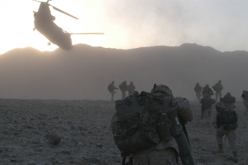 Soldiers in desert with helicopter