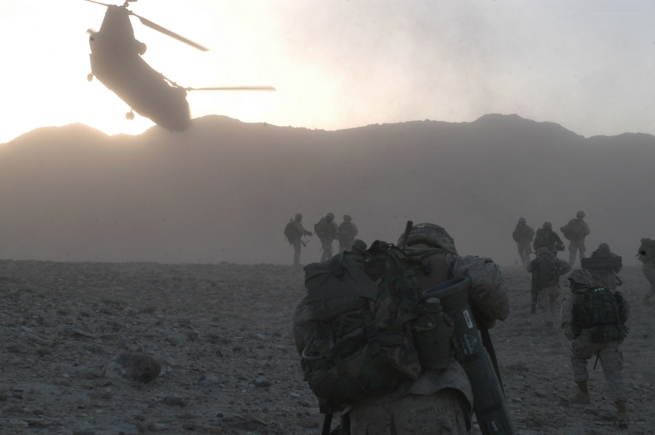 Soldiers in desert with helicopter