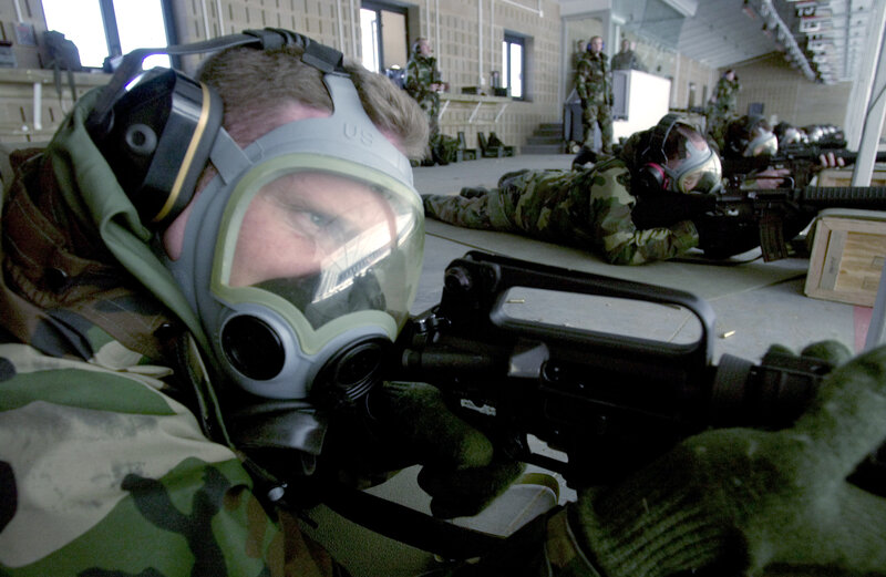 Soldiers in gas masks at shooting range