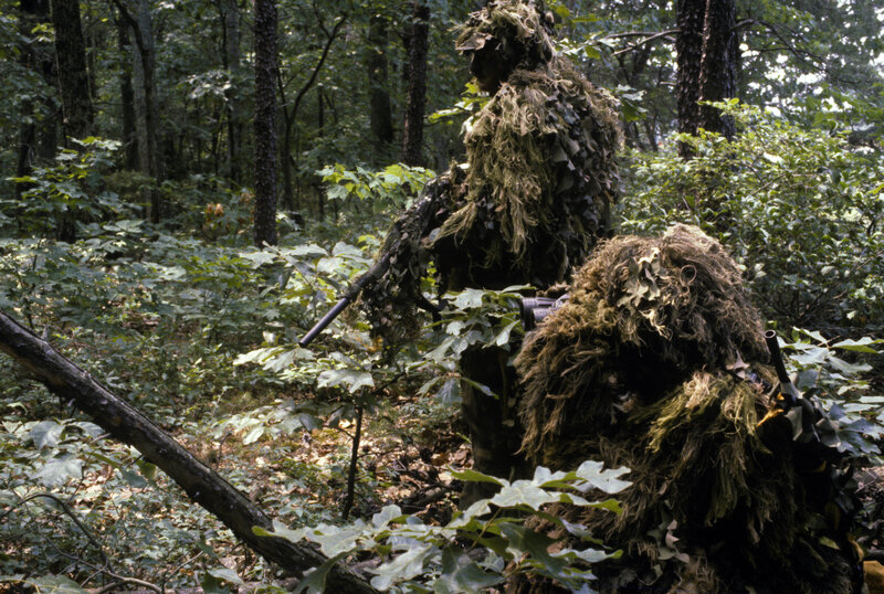 Soldiers in ghillie suits in forest
