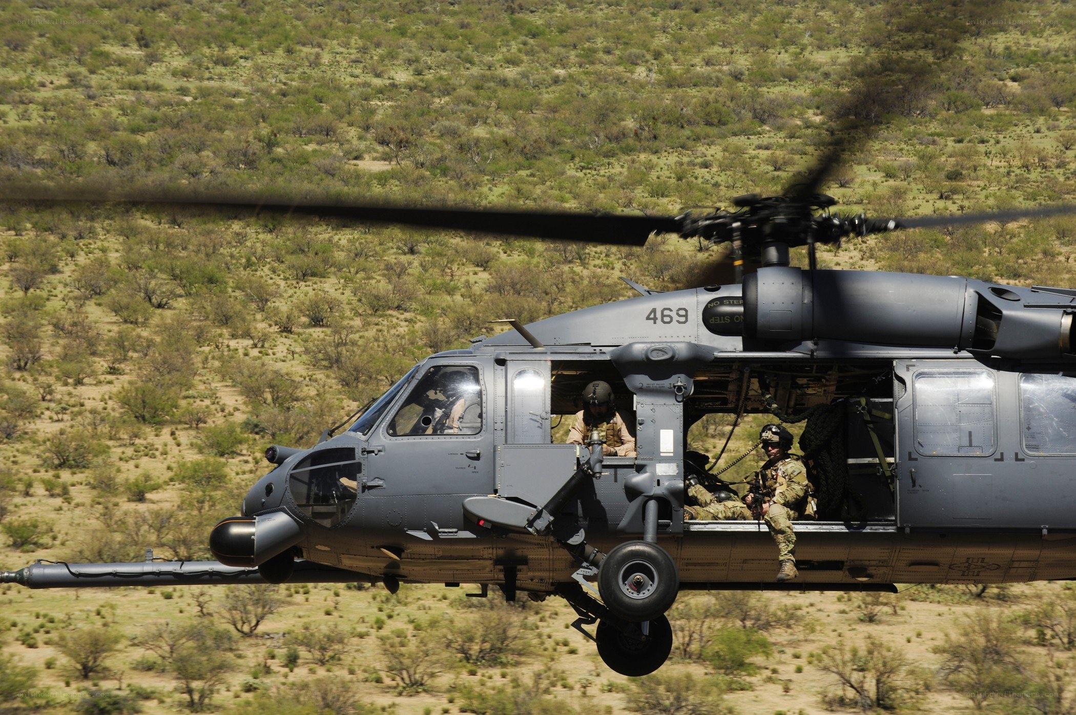 Soldiers in helicopter over desert