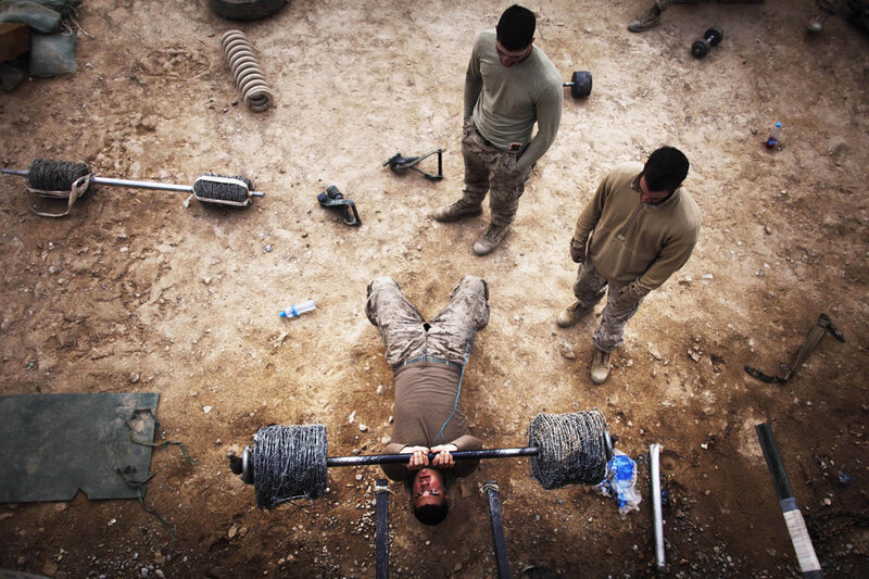 Soldiers lifting barbell in field