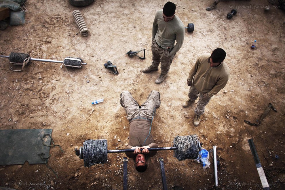 Soldiers lifting barbell in field