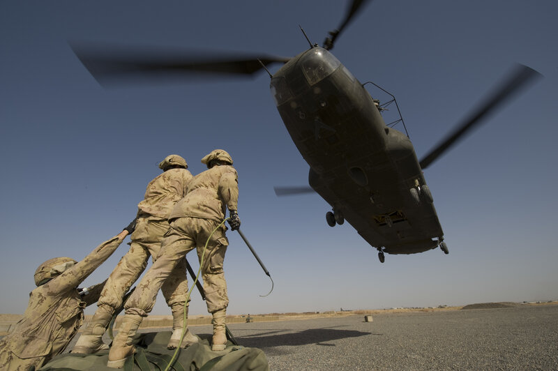 Soldiers loading cargo onto helicopter