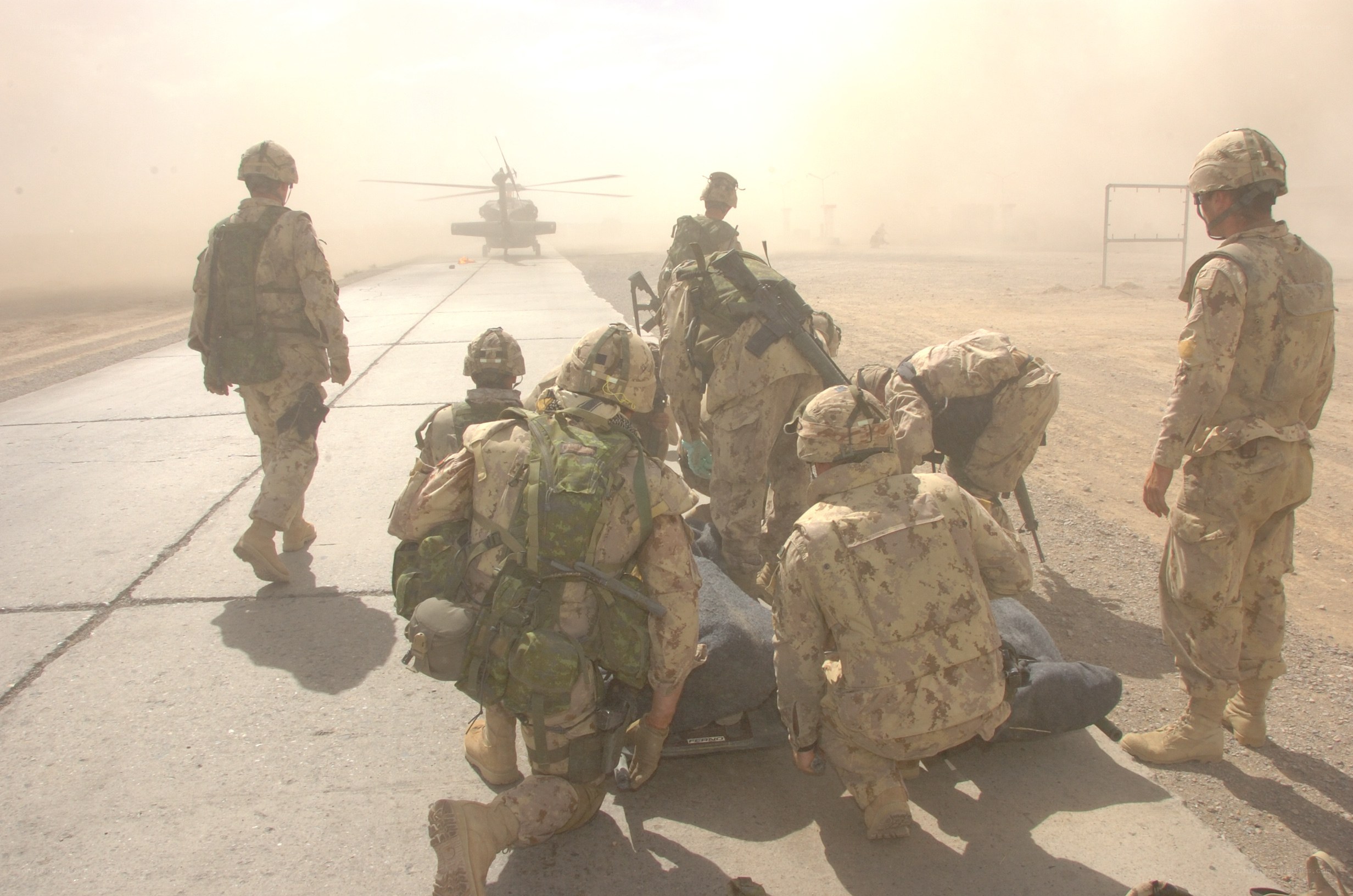 Soldiers loading casualty on stretcher