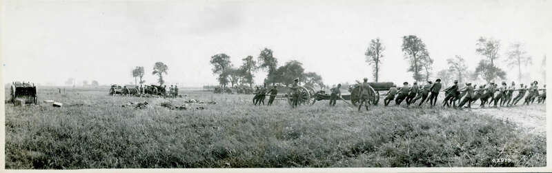 Soldiers moving artillery in a field