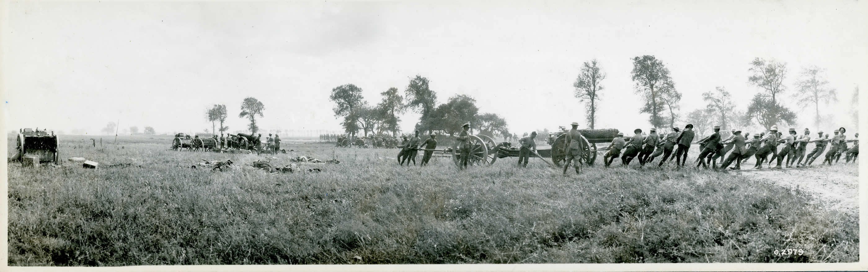 Soldiers moving artillery in a field