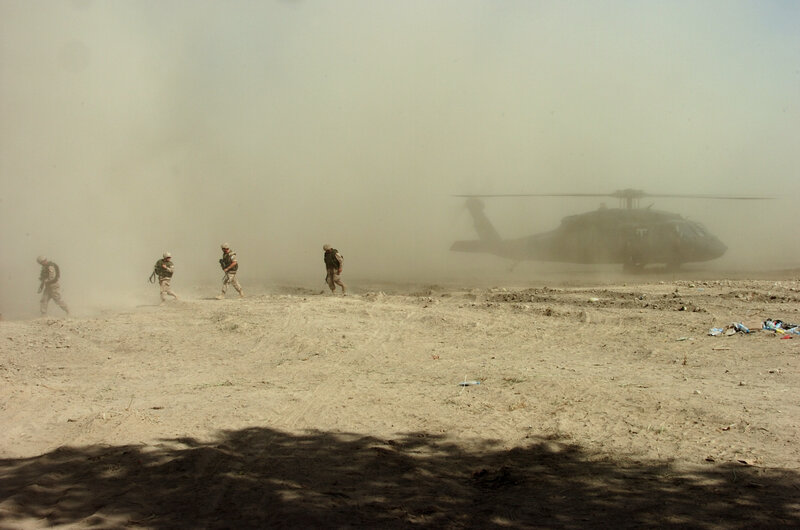 Soldiers near helicopter in desert