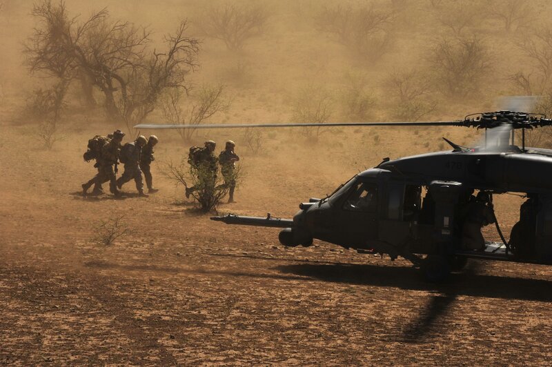 Soldiers near helicopter in desert