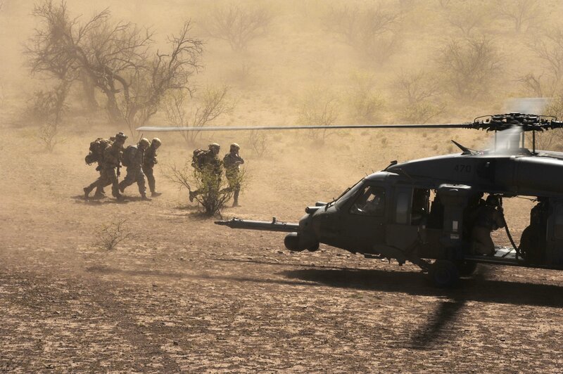 Soldiers near helicopter in desert