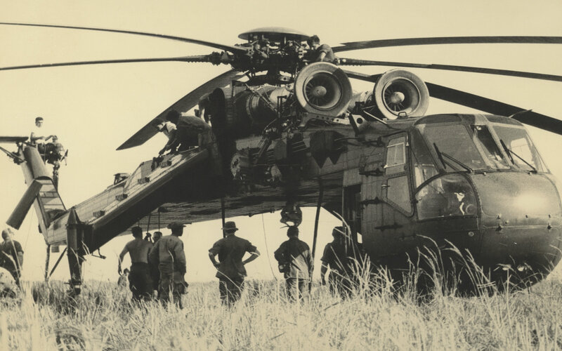 Soldiers near helicopter in field