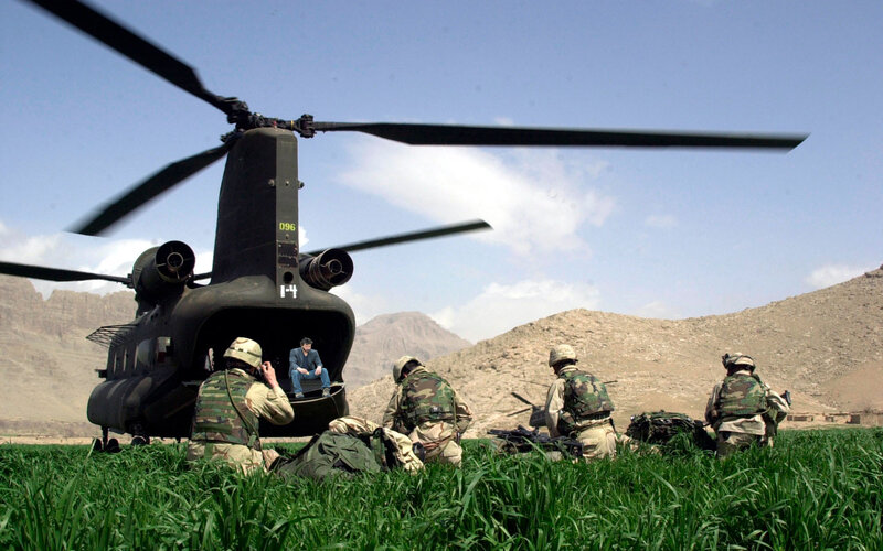 Soldiers near helicopter in field