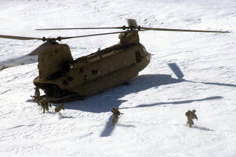 Soldiers near helicopter in snow