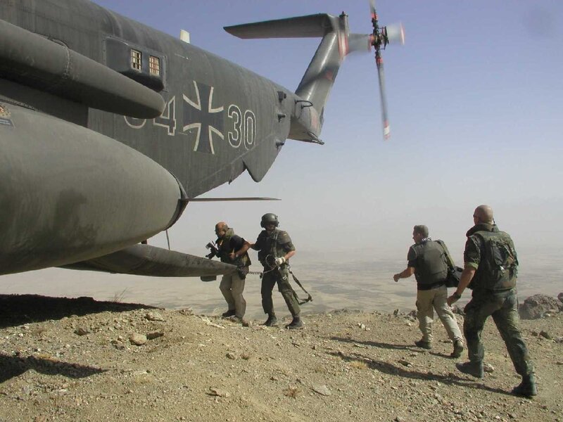 Soldiers near helicopter on hill