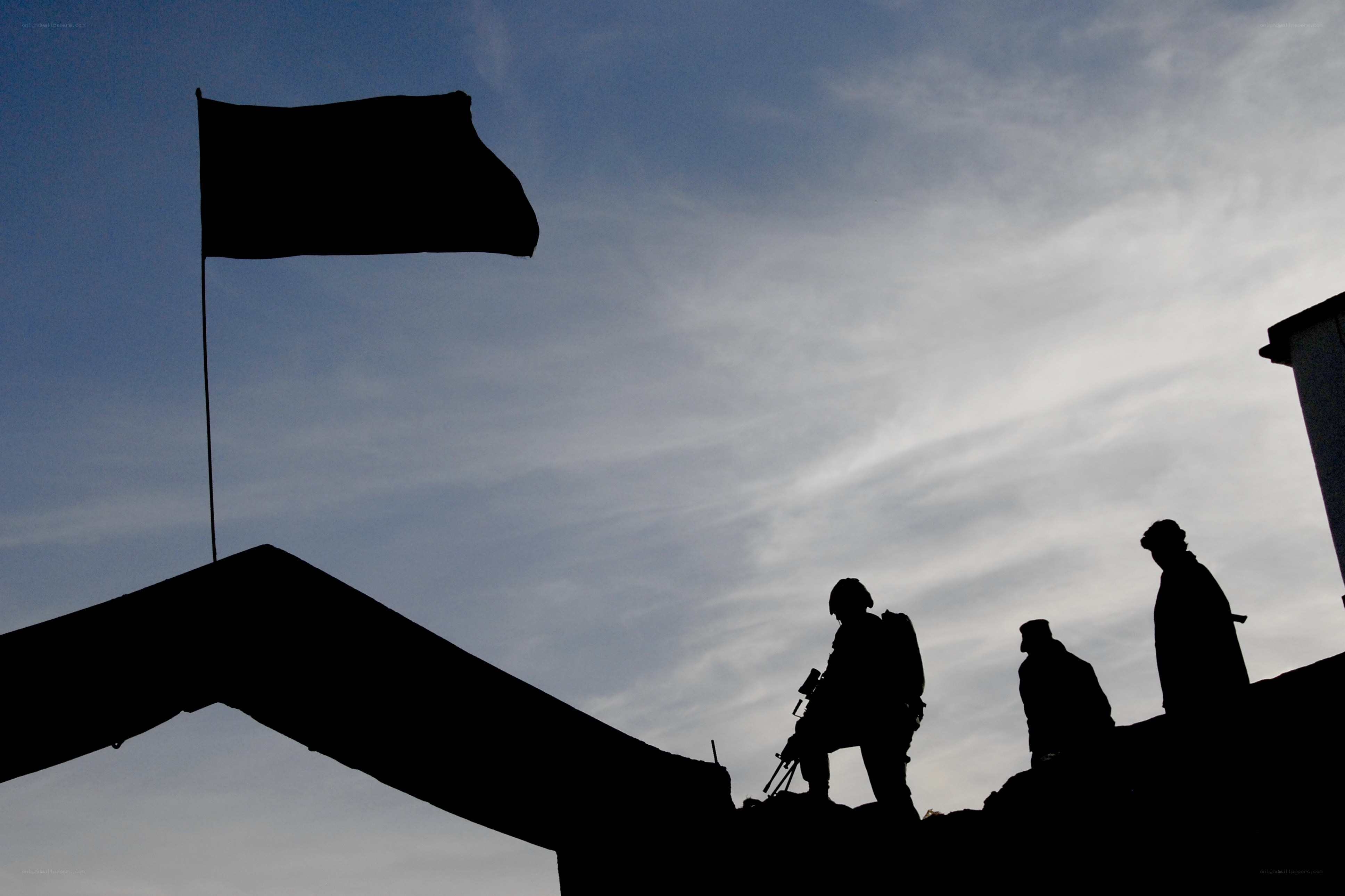 Soldiers on a rooftop at dusk