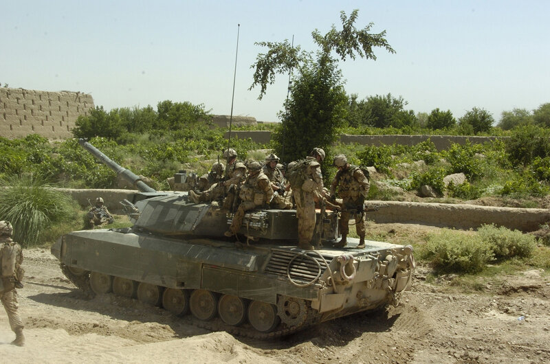 Soldiers on a tank in a rural area