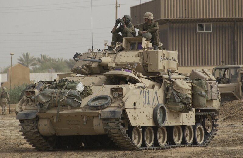 Soldiers on a tank in desert
