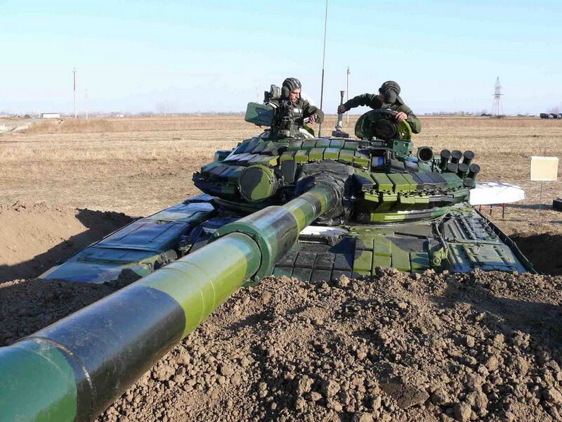 Soldiers on a tank in field