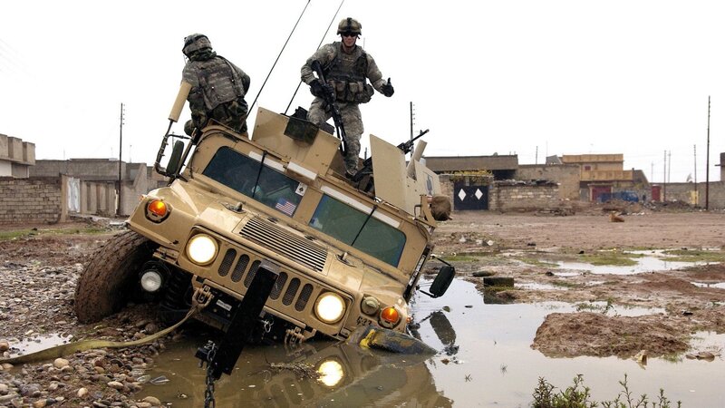 Soldiers on Humvee in muddy terrain