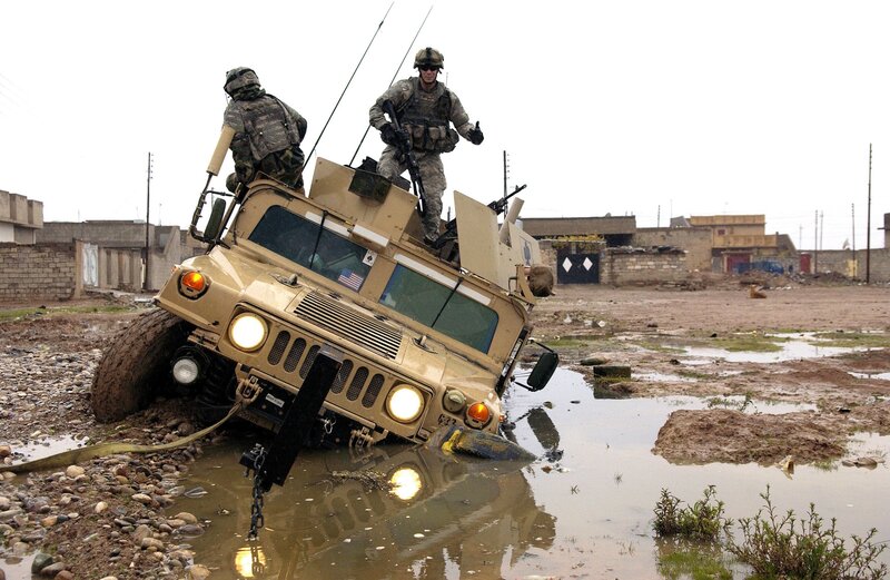 Soldiers on Humvee in muddy terrain