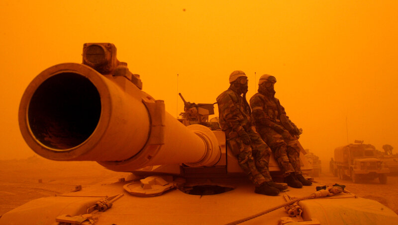 Soldiers on tank in sandstorm