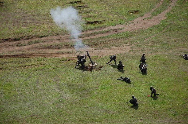 Soldiers operating artillery in field