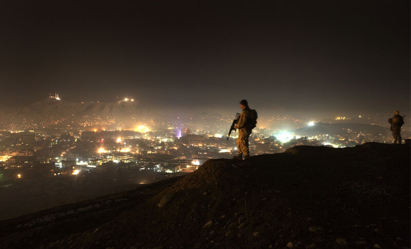 Soldiers overlooking a city at night