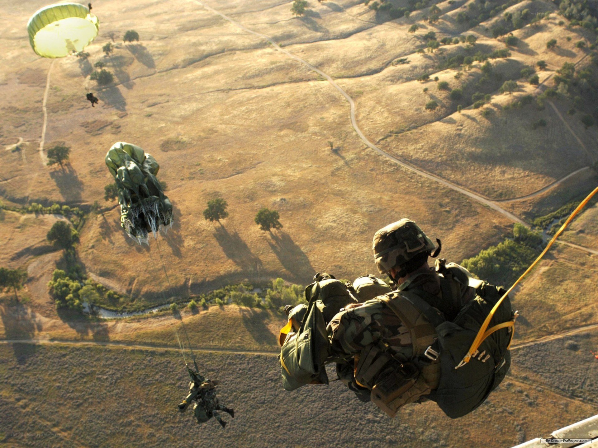 Soldiers parachuting over hills